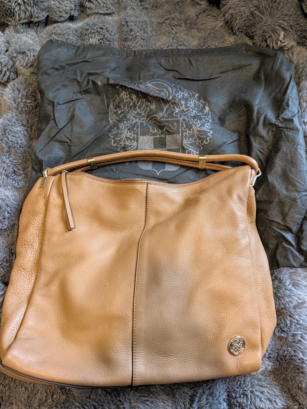 This is a tan pebbled leather Vince Camuto hobo shoulder bag featuring a signatu